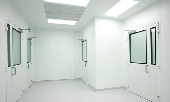 Clean room corridor with flush white wall panels, double doors and vision panels
