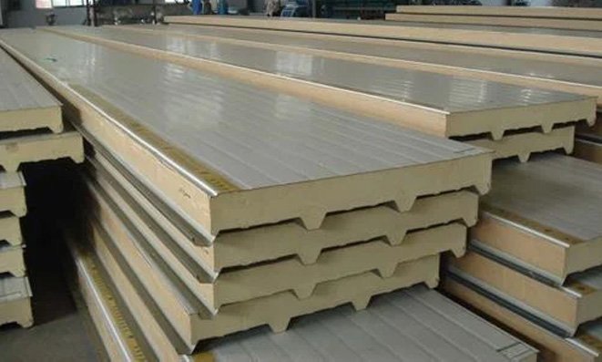 Stack of sandwich panels showing the insulating foam core between two metal facings